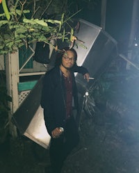 a man standing next to a metal object in the dark